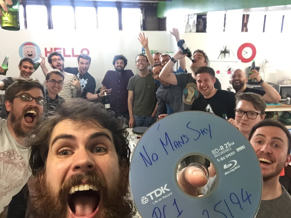 Sean Murray and Hello Games staff hold No Man's Sky DVD